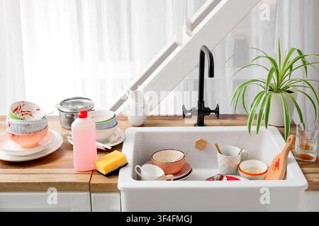 Kitchen sink full of dirty dishes and utensils, household chores and cleaning concept, domestic life Stock Photo