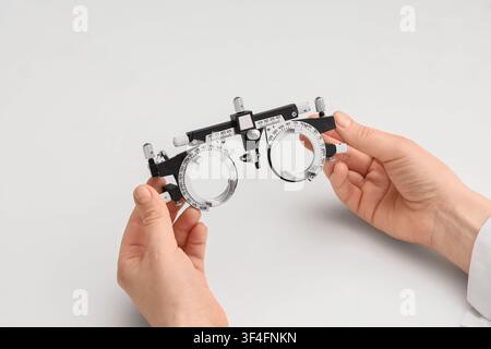 Optometrist holding a phoropter trial frame for eye examination and vision testing, isolated on a white background, this instrument helps determine th Stock Photo