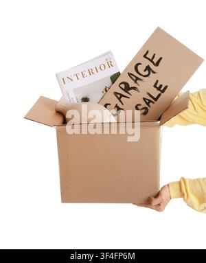 Female hands holding box of unwanted stuff and cardboard with text GARAGE SALE on white background Stock Photo
