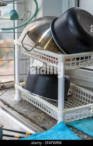 Kitchen utensils drying on countertop near window Stock Photo
