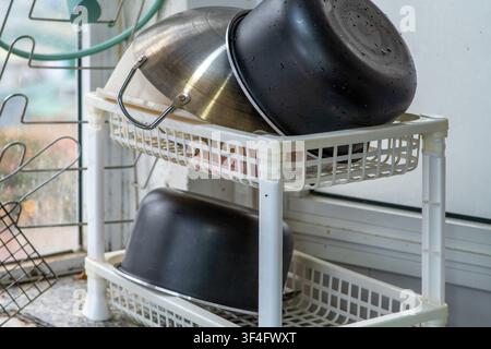 Stacked kitchen bowls drying in wire rack Stock Photo