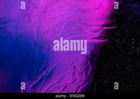 Abstract liquid surface displaying flowing purple and blue colors with tiny air bubbles Stock Photo
