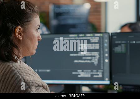 Database Designer Coding Across Multiple Screens in a software development office, showing programmers collaborating on source code, algorithms and data coding workflow. Stock Photo