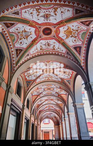 Bologna, Italy - May 2026: Low angle perspective of a vaulted historic portico arcade adorned with intricate colorful Renaissance frescoes Stock Photo