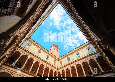 Bologna, Italy - May 2026: Low angle geometric perspective of the Renaissance courtyard at Archiginnasio with double loggia framing the blue sky Stock Photo