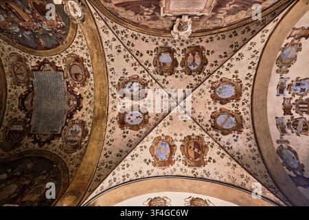 Bologna, Italy - May 2026: Directly below view of frescoed vaulted ceiling with historic heraldic coats of arms at Archiginnasio di Bologna Stock Photo