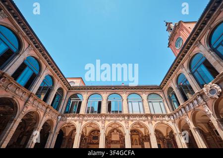 Bologna, Italy - May 2026: Low angle view of the historic courtyard and clock tower at Archiginnasio di Bologna Stock Photo