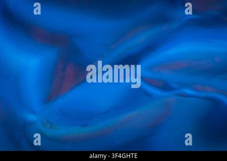 Abstract composition of deep blue flowing forms with soft cyan and violet accents, creating layered waves, smooth curves and a calm, atmospheric visua Stock Photo