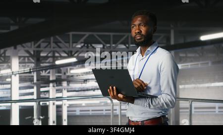 System administrators in data center using laptop to monitor neural network LLM visualization. Server hub teamworking colleagues overseeing rigs powering machine learning processes Stock Photo