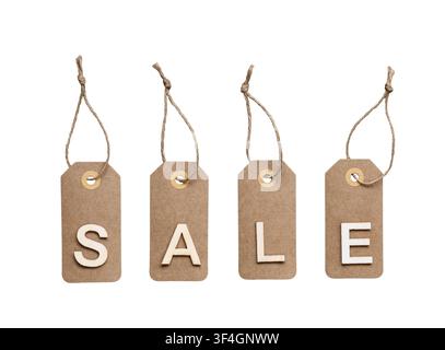 Four brown kraft paper tags hanging by twine with white wooden letters spelling SALE isolated on white background Stock Photo