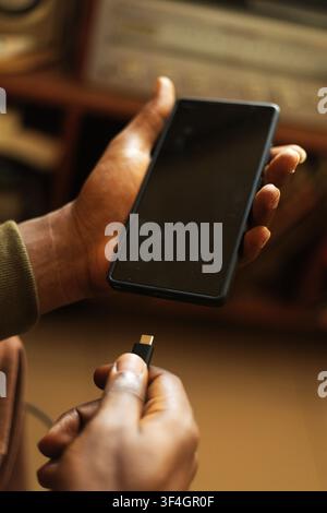 A hand charging a smart phone Stock Photo