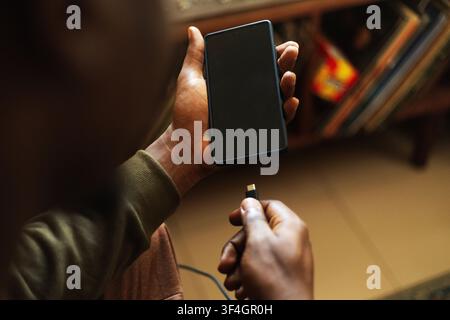 A hand charging a smart phone Stock Photo