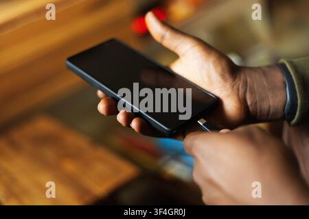 A hand charging a smart phone Stock Photo