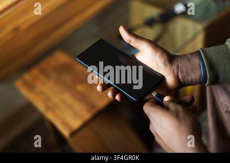 A hand charging a smart phone Stock Photo