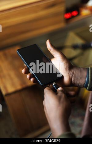 A hand charging a smart phone Stock Photo