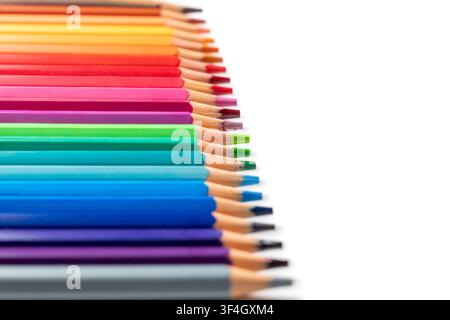 Colorful wooden pencils arranged in a rainbow spectrum on a white background with copy space. Art, education, creativity, design, stationery Stock Photo