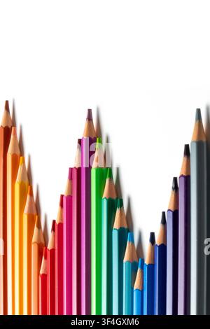 Colored pencils arranged in staggered lengths on a white background with copy space. Creates a bar chart concept symbolizing financial growth Stock Photo