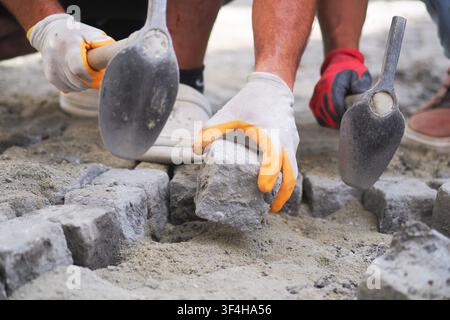 Workers laying bricks on-site in the afternoon Stock Photo