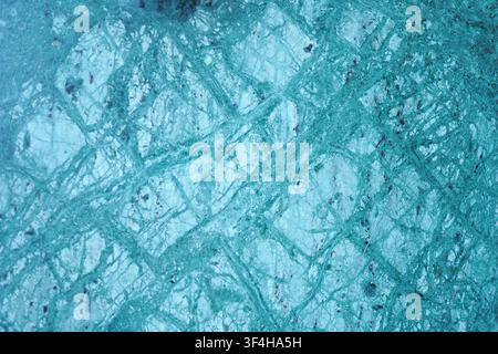 Ice surface shows cracks and patterns in a frozen location Stock Photo