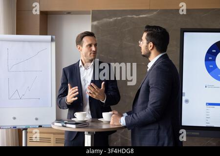 Multiethnic businessmen planning business strategy, discussing finances in conference room Stock Photo