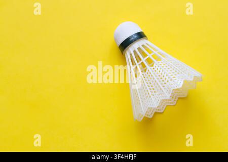 Badminton shuttlecock on a yellow background. Shuttlecock close-up. Stock Photo