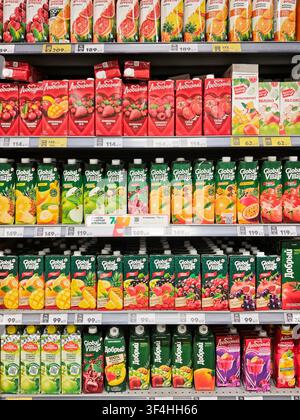 Kirov, Russia - March 05, 2026: Shoppers browse supermarket shelves filled with different juice brands in a grocery store aisle during the day. Stock Photo