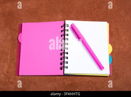 Open notebook with pink bookmark on a pink background Stock Photo