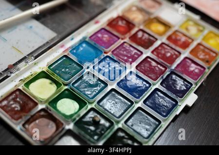 Close up of a colorful watercolor paint palette. Concept: Art supplies store marketing, creativity, and drawing education Stock Photo