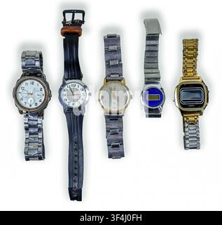 Five unique retro clocks are displayed in a row, featuring metal and plastic bands. Each clock has a distinct dial design, reflecting various styles f Stock Photo
