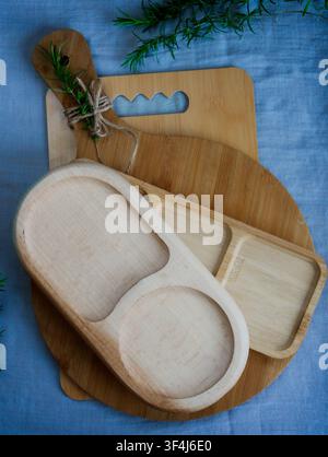Empty bamboo serving tray with three compartments placed on a round wooden cutting board over light linen fabric. Minimal kitchen tableware with copy Stock Photo