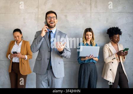 Busy smiling executive business team using digital devices in office. Diverse professional people Stock Photo