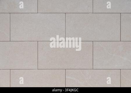 A seamless background texture of light beige rectangular stone tiles with subtle veining, perfect for architectural or design applications Stock Photo