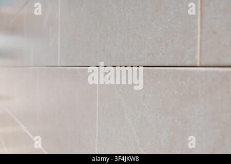 A detailed perspective of a modern beige tiled surface, showcasing its fine texture and precise grout spacing Stock Photo