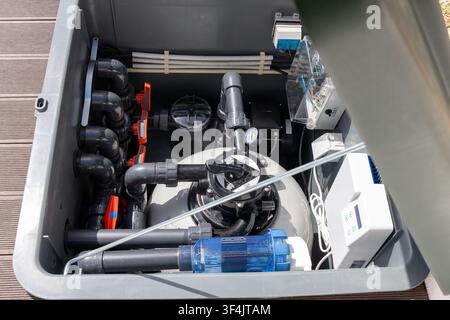 A comprehensive view inside a pool equipment box showcasing the intricate network of pipes, valves, and electronic controls for water purification Stock Photo
