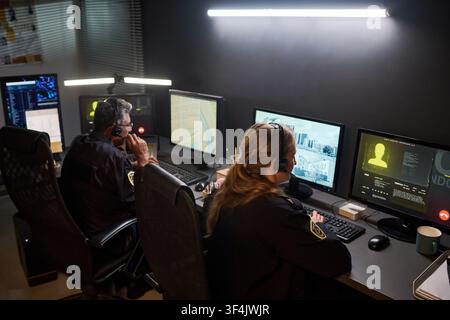 Security Officers Monitoring Surveillance Screens Stock Photo