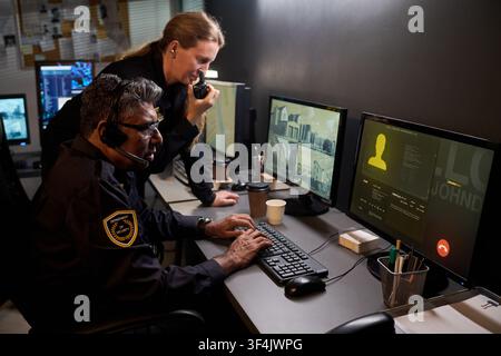 Security Team Monitoring Surveillance Data in Control Room Stock Photo