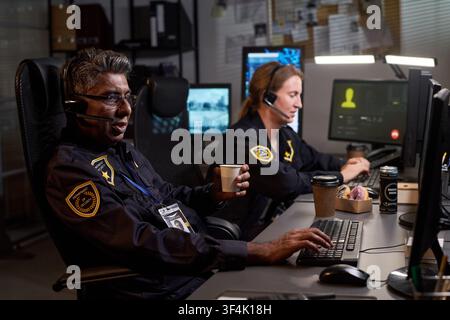 Security Officers Working Overnight in Command Center Stock Photo