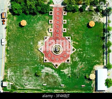 Aerial view of the landscaped courtyard at Ghazi University with a geometric red brick pattern and central fountain surrounded by green lawns in Dera Stock Photo