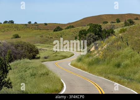 Empty winding road through hills Stock Photo