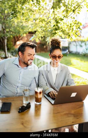 Business colleagues collaborating remotely outdoor using laptop Stock Photo