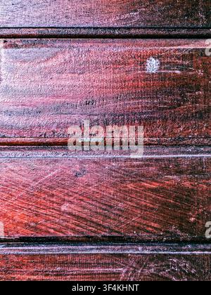Close-up of rich dark brown and reddish wooden planks with visible grain, scratches, and horizontal panel lines. Stock Photo