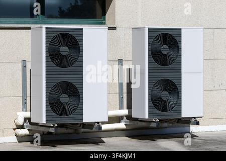 Two big Air conditioner compressor units installed outside of a building Stock Photo