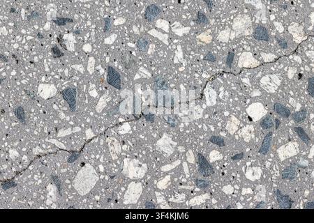 Abstract background of a polished aggregate concrete with a crack. Full frame Stock Photo