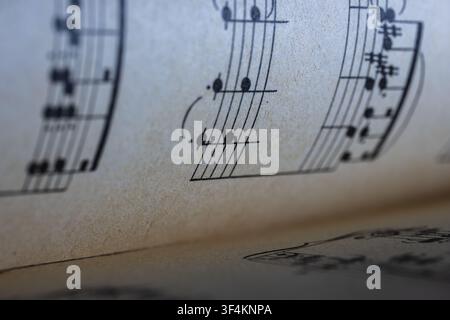 Close-up of aged sheet music displaying musical notes and staves Stock Photo