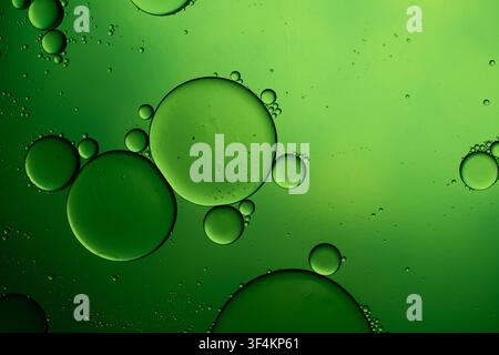 Green oil drops creating abstract bubbles on water Stock Photo