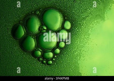 Green bubbles forming an abstract pattern on a liquid surface, showing texture and foam Stock Photo