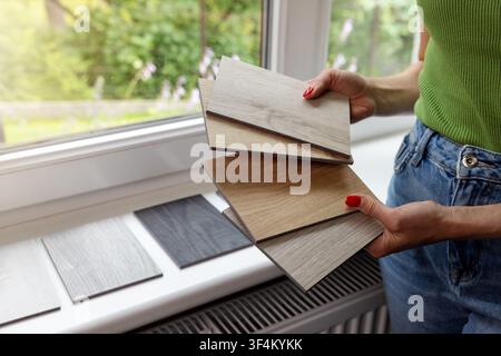 Woman choosing materials from wood samples for home flooring and furniture. Interior design and renovation Stock Photo