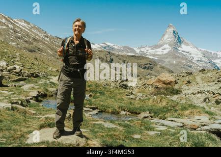 Happy hiker enjoying mountain landscape with iconic peak Stock Photo