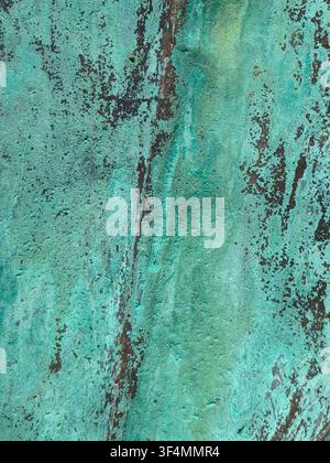 Abstract background of an oxidized copper surface covered in vibrant green patina and dark weathered verdigris textures. Stock Photo