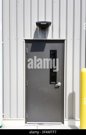 Industrial Gray Metal Exterior Door on Corrugated Siding Wall Stock Photo